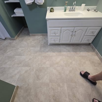 New bathroom flooring next to a white vanity