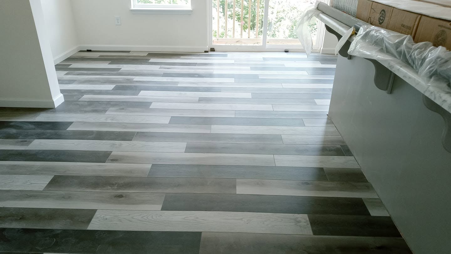 Gray wood-look flooring flowing through a Clarks kitchen and dining project